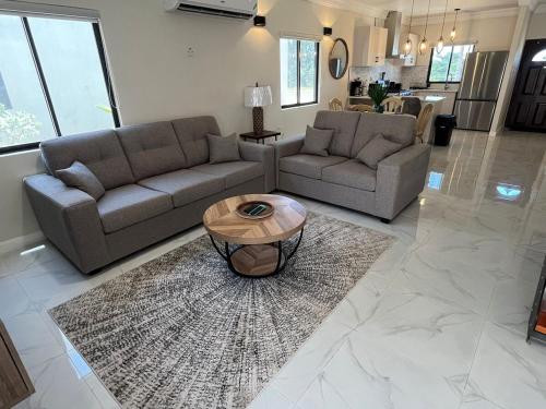a living room with two couches and a coffee table at Drift & Discovery New Modern Stay, Mins to Beach! in Brissett Run