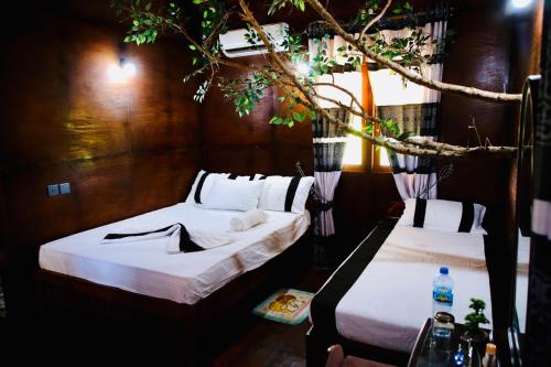 two beds in a room next to each other at Lake Wind Resort & Restaurant in Weerawila