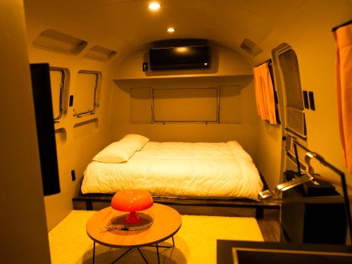 a small room with a bed and a table at FOG villa&spa in Kirishima