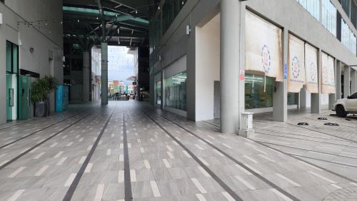 an empty hallway of a building with glass windows at Luxe Loft 3BR Emporium 9pax in Kuching