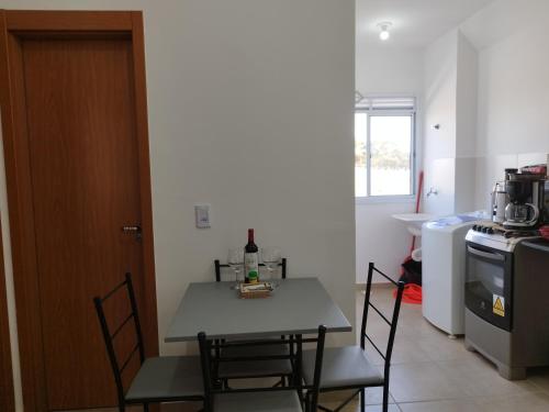 a kitchen with a table with a bottle of wine on it at Apartamento novo e aconchegante! in Jaboticabal
