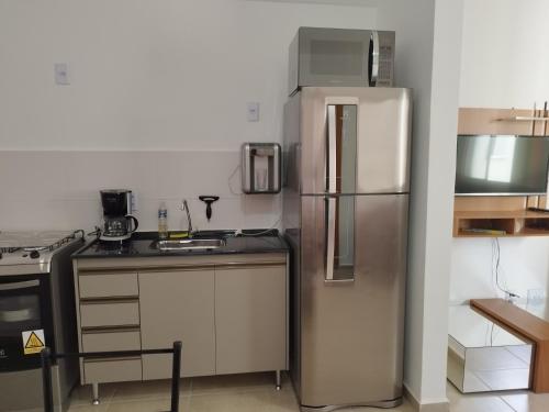 a kitchen with a stainless steel refrigerator and a stove at Apartamento novo e aconchegante! in Jaboticabal
