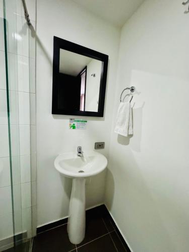 a bathroom with a sink and a mirror at HOTEL JARDIN 38 in Pasto