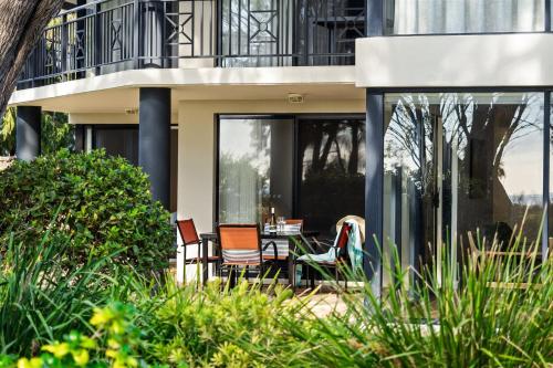 two chairs and a table in front of a building at 2 CapeView Beachfront Geographe Bay in Broadwater