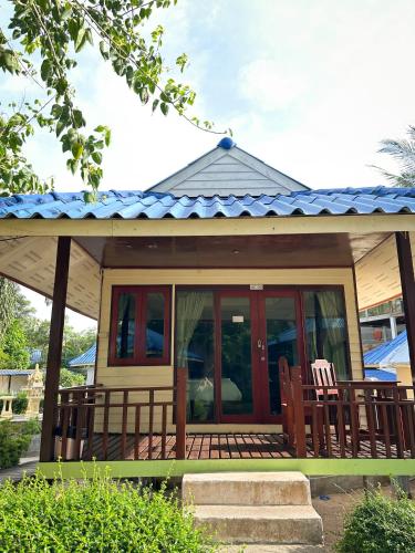 a small house with two chairs on a porch at Pranee Bungalow in Koh Tao