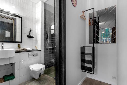 a white bathroom with a toilet and a sink at City Center Hotel in Reykjavík