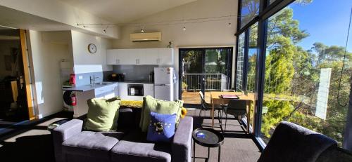 a living room with a couch and a kitchen with a table at Tamar Tonic - Lush River Views in Grindelwald