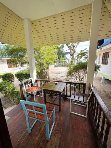 a porch with a table and chairs on it at Pranee Bungalow in Koh Tao