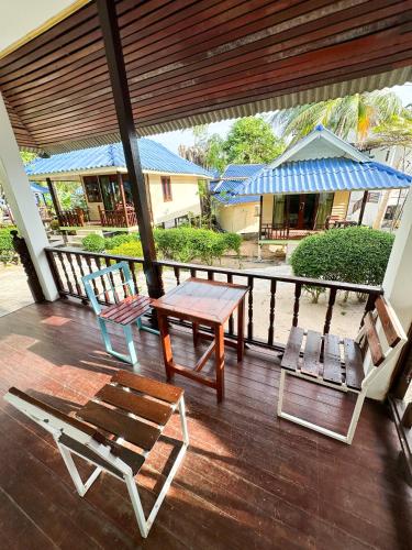 a porch with two chairs and a table and a bench at Pranee Bungalow in Koh Tao
