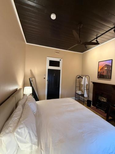 a bedroom with a white bed with a black ceiling at Royal Oak Hotel in Ballarat