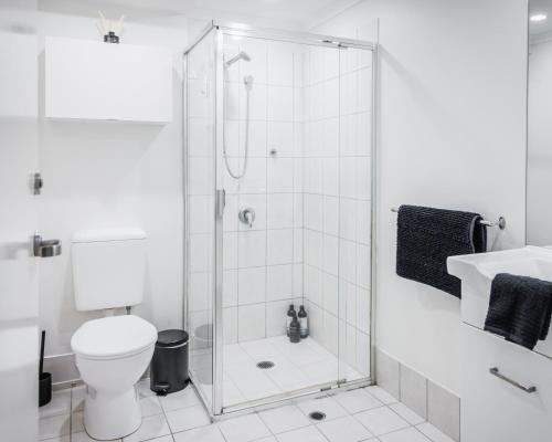a bathroom with a shower and a toilet and a sink at Melbourne Central Gem in Melbourne