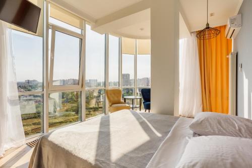 a bedroom with a bed and a large window at Gagarin Plaza Apartment in Odesa