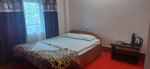 a small bedroom with a bed and a table at Nigaah Homestay By StayApart in Mirik