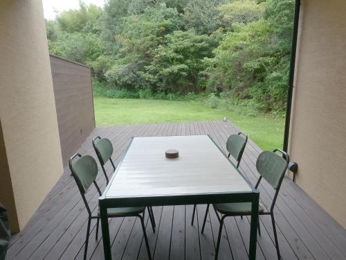 a table and chairs on a deck with a view at 伊勢志摩パールヴィレッジ ヴィラ in Shima