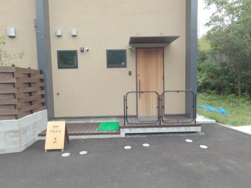 a door of a house with a sign in front of it at 伊勢志摩パールヴィレッジ ヴィラ in Shima
