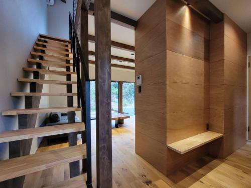 a staircase in a house with wooden walls at 伊勢志摩パールヴィレッジ ヴィラ in Shima