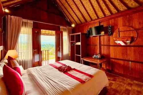 a bedroom with a bed with a red bow on it at Munduk Luwih Ecolodge Bedugul by AGATA in Tabanan