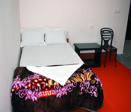 a bedroom with a bed and a table with a chair at Nigaah Homestay By StayApart in Mirik
