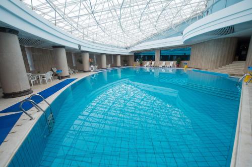 a large swimming pool in a building with a ceiling at Grand Sun City Hotel-Located city center Metro Access in Changsha