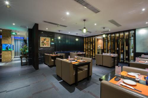 a restaurant with tables and chairs in a room at Grand Sun City Hotel-Located city center Metro Access in Changsha