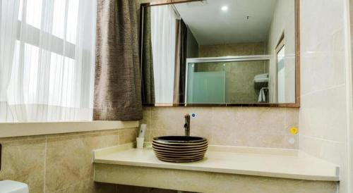 a bathroom with a sink and a mirror at 7Days Premium Yichang Railway Station East in Yichang