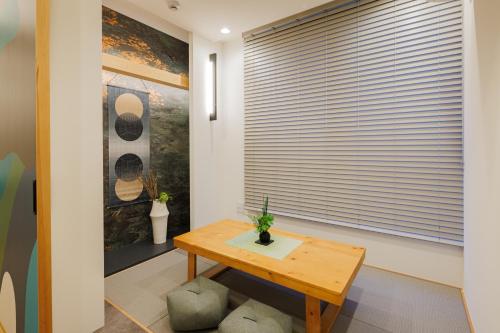a room with a wooden table and a window with blinds at Tokyo Sky Suite Hotel in Tokyo