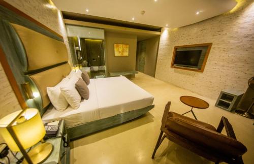 a bedroom with a bed and a desk and a chair at Pledge Scape in Negombo