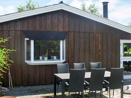 a table and chairs in front of a building at 6 person holiday home in Væggerløse in Bøtø By