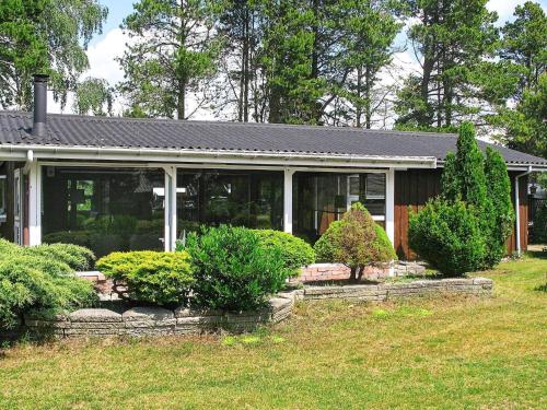 a house with some bushes in front of it at 6 person holiday home in Væggerløse in Bøtø By