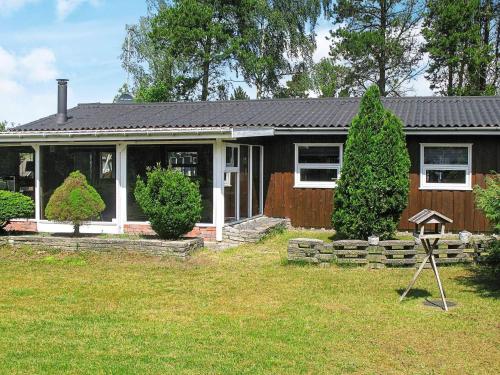 a small house with a porch and a yard at 6 person holiday home in Væggerløse in Bøtø By