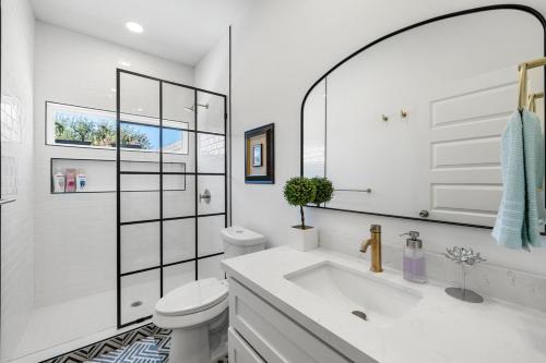 a white bathroom with a toilet and a sink at 3BR lovely Townhouse in McAllen in McAllen