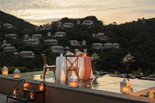 a table with candles and lights on a balcony at Banyan Tree Samui in Lamai