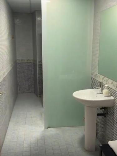 a white bathroom with a sink and a mirror at ALZIRA BONITA APARTAMENTO CON DOS HABITACIONES CON VISTAS AL RiO JUCAR in Alzira