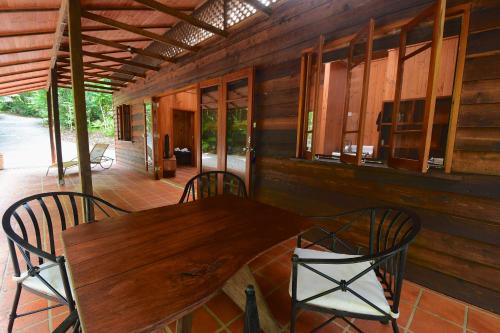 una mesa de madera y sillas en un porche en Daintree Cascades, en Cape Tribulation
