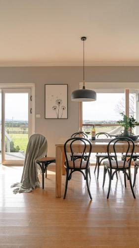 a dining room with a table and chairs with a view at Milton Woodstock Homestead Luxury retreat with NEW 11M POOL just minutes from the beach in Milton