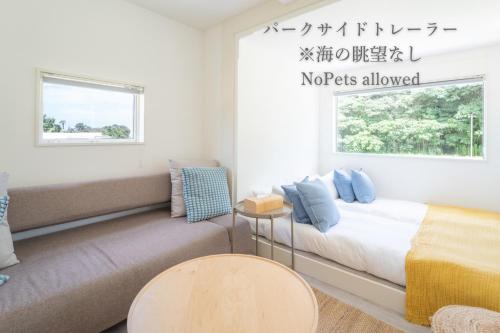 una sala de estar con una cama y un sofá en TOMORROW-COAST, en Kitakyushu