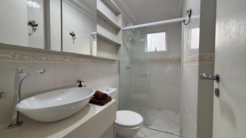 a bathroom with a sink and a toilet and a shower at Apê central BC | 450m da praia + A/C + vaga in Balneário Camboriú