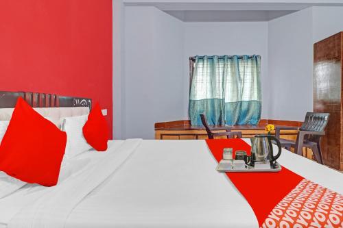 Un dormitorio con una cama con almohadas rojas. en Hotel O FOURTEEN, en Kondapur