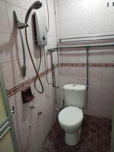 a bathroom with a toilet and a phone on the wall at Sacha Semarak in Baling