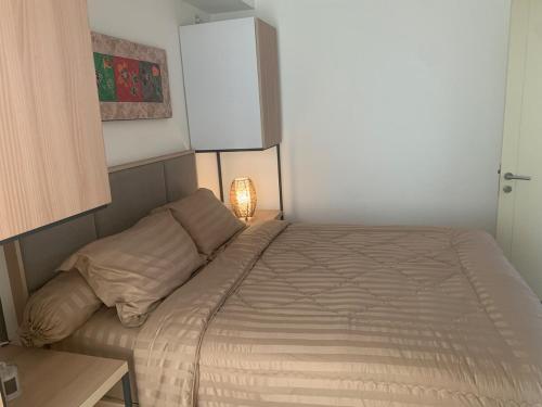 a small bedroom with a bed and a lamp at M-town residence cozy apartment gading serpong in Pumpangsineng