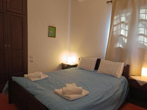a bedroom with a bed with towels on it at Άνετος χώρος με parking, αυλή και θαυμάσια θέα in Makrinítsa