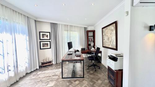 an office with a desk and a computer in a room at VILLA SCALINA Seaside Hideaway - 7 Bedroom - Pool - Gym - Walk to beach in Calodyne