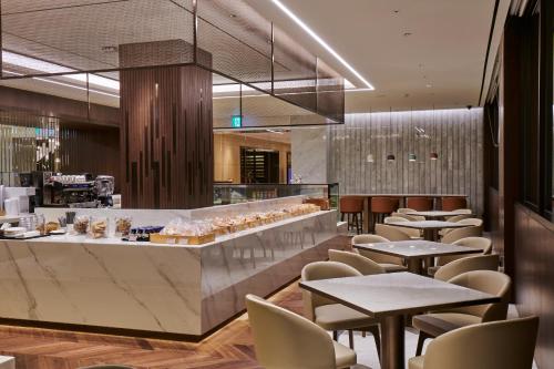 a restaurant with tables and chairs and a bar at Hotel Hyundai by Lahan Ulsan in Ulsan