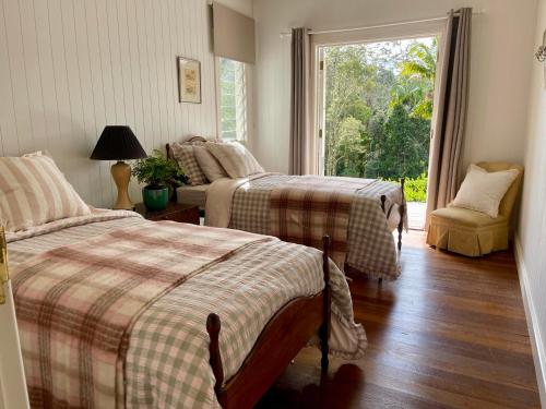 a bedroom with two beds and a window at Nightcap Ridge - Byron Bay Hinterland in Dorroughby