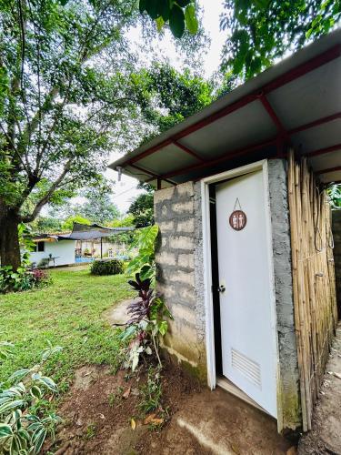 a small house with a white door and a yard at Barracuda Swim Club's Homestay - Aircon Room with Pool in Coron