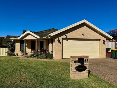 a house with a garage with a fire hydrant in the yard at Budgaribah in Old Bar