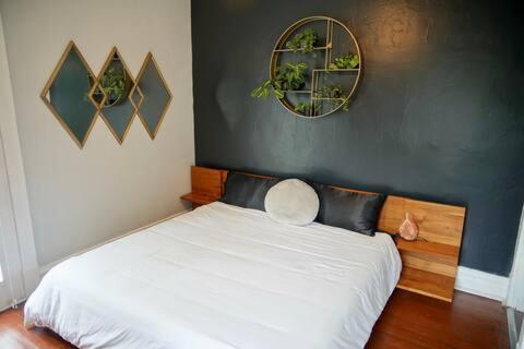 a bedroom with a white bed and two mirrors at Cute Neighborhood Rainbow Apt in Saint Louis