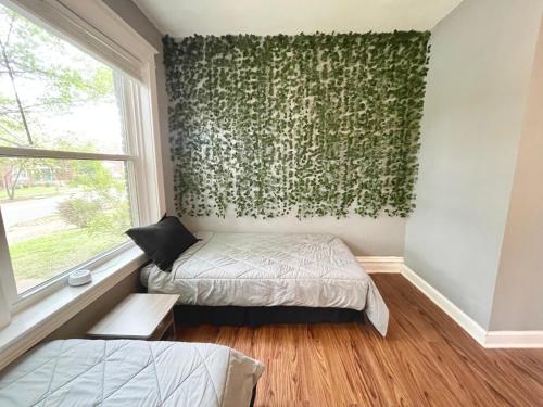 a bedroom with two beds and a window at Cute Neighborhood Rainbow Apt in Saint Louis