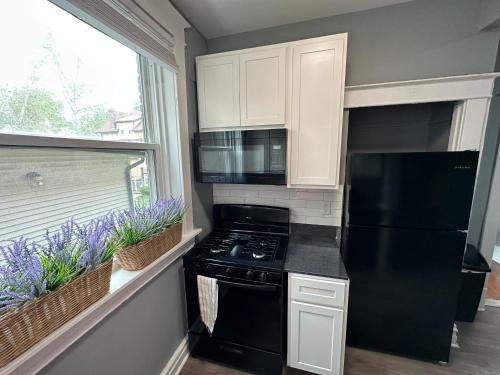 a kitchen with a black stove and a window at Cute Neighborhood Rainbow Apt in Saint Louis