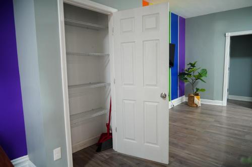 a room with a white door and shelves at Cute Neighborhood Rainbow Apt in Saint Louis